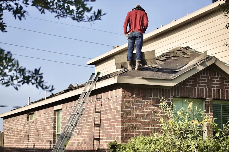 Professional roofer working on a residential roof in Mattapan Square